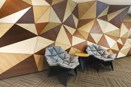 Modern lobby with abstract wooden mosaic wall and armchairs. Rest zone in hotel reception, copy spaceの写真素材