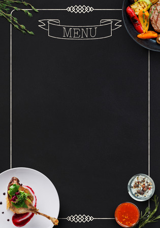 Design concept for restaurant menu mockup. Black rustic board with white inscription and tasty dishes frame, top view, copy space for textの写真素材