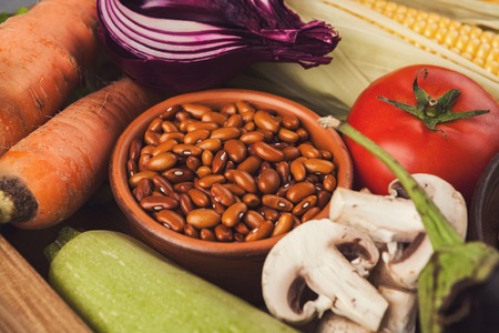 Heap of fresh organic tasty vegetables and beans background. Healthy natural food on slate table, cooking ingredients, organic vegetarian harvestの写真素材