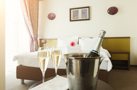 Two glasses of and champagne in ice bucket in hotel. Romance, room service, relax concept, copy spaceの写真素材