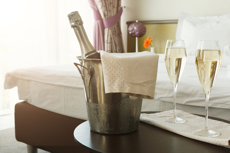 Two glasses of and champagne in ice bucket in hotel. Romance, room service, relax concept, copy spaceの写真素材