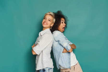 Happy emotional female friends posing and having fun at blue background, copy spaceの写真素材