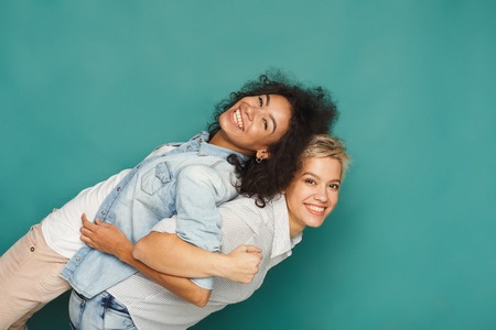 Happy emotional female friends posing and having fun at blue background, copy spaceの写真素材