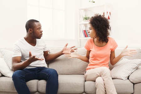 Young african-american couple quarreling at home, offended at each other . Family relationship difficulties conceptの写真素材