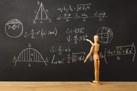 Educational background. Wooden marionette writing mathematics sums with chalk on blackboard. Back to...