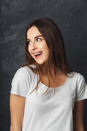 Young laughing attractive woman portrait. Beautiful girl having fun, dark backgroundの写真素材