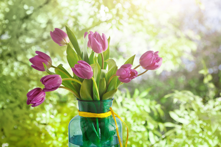 Beautiful flowers bouquet background. Violet tulips at summer garden background with copy space. Mockup for greeting cardの写真素材