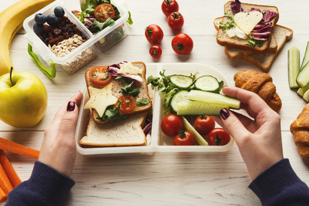 Healthy snack at office workplace. Businesswoman eating organic vegan meals from take away lunch box...