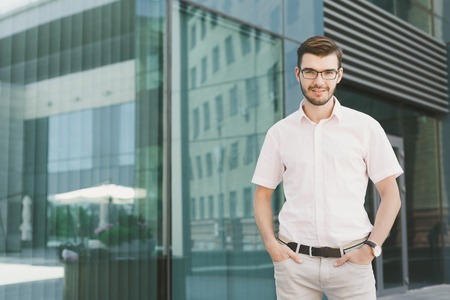 Confident successful businessman outdoors. Young stylish man posing at modern office center, copy spaceの写真素材