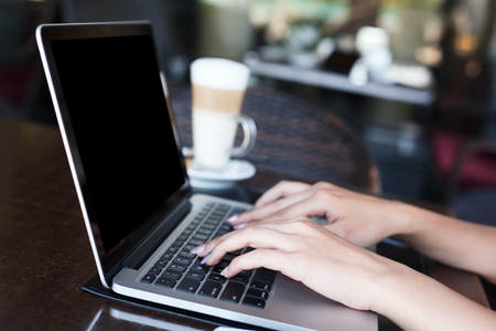 Female hands with laptop closeup. Woman working outdoors on computer with blank screen for copy space. Technology, communication and remote working concept.の写真素材