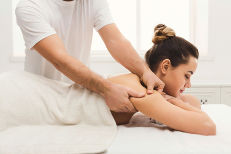 Professional massage advertisement concept. Young woman getting classical body therapy with organic oils at spa. Relaxation and wellness backgroundの写真素材