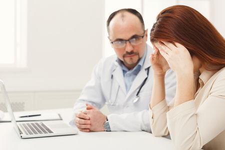 Serious doctor consulting and diagnose the woman, healthcare and medical concept, copy space. Selective focus on upset patientの写真素材