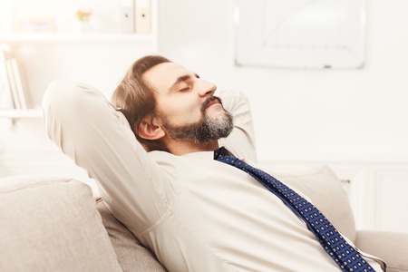 Successful business background. Relaxed businessman taking rest in modern office, copy spaceの写真素材
