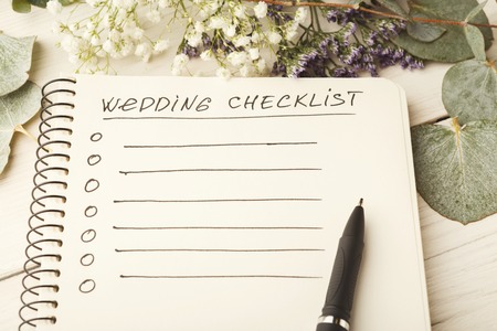 Wedding checklist with copy space and cute flowers on the white desktop. Marriage planner concept, copy space.の写真素材