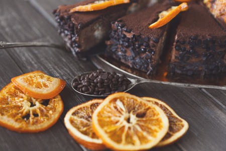 Chocolate cake with cream and profiterole, decorated with candied oranges. Traditional creamy dessert, copy spaceの写真素材