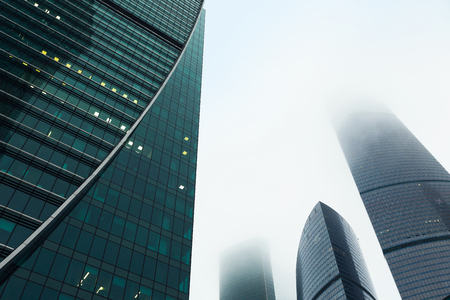 Skyscrapers in the financial district. Modern office buildings against gloomy sky, low angle view. Business and real estate background, copy spaceの写真素材