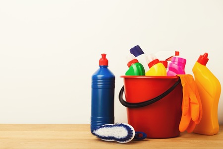 Variety of house cleaning products on wood table at white background, closeup. Bucket, brush, rubber gloves, disinfection items. Tidying up, spring-cleaning concept, copy spaceの写真素材