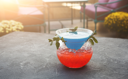 Traditional cocktail in modern serving. Soft drink with blue curacao syrup, coconut rum and pineapple juice. Cold beverage on gray table with copy space. Mockup for blue hawaii recipeの写真素材