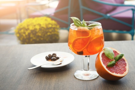 Traditional italian spritz cocktail. Soft drink with red bloody orange, prosecco and pine cones confiture. Exclusive bar menu concept, copy spaceの写真素材