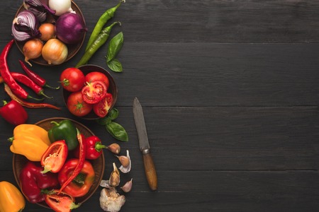 Fresh organic vegetables on wood background. Wooden workspace and knife on rustic kitchen table with natural cooking ingredients, top view, copy spaceの写真素材