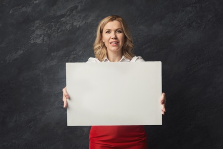 Happy businesswoman with blank white paper. Happy woman holding advertising sheet, copy spaceの写真素材