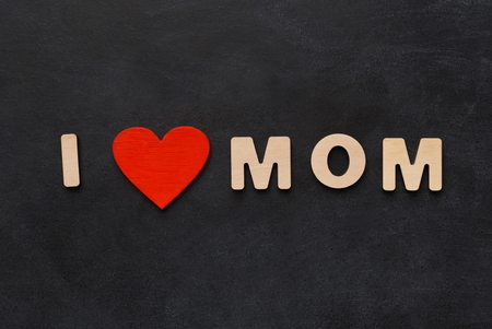 I love mom spelled with wooden letters on black background. Mothers day concept, top view, copy spaceの写真素材