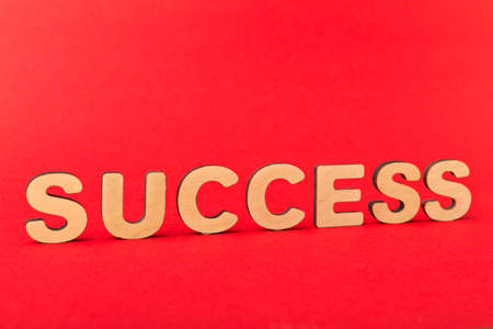 Motivation poster. Word Success spelled with wooden letters on red background. Achievement, progress and development concept, copy spaceの写真素材