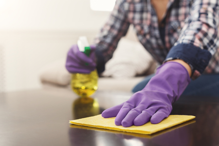 Woman using spray cleaner on wooden surface. Unrecognizable girl polishing furniture, housework and chores concept, copy spaceの写真素材