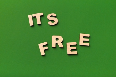 It is free inscription on green background. Wooden letters phrase, top view, copy space. Ad, charity, gift and bonus conceptの写真素材