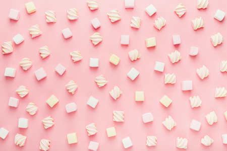 Marshmallows on pink background, flat lay or top view. Background or texture of mini marshmallows. Winter food background concept.の写真素材