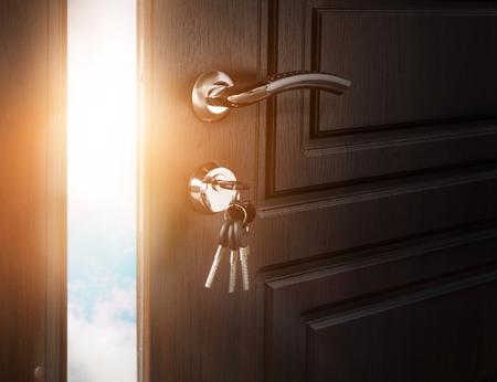 Half open door with keys in keyhole. Doorway to heaven and success. Entrance or exit, dreams and freedom conceptual backgroundの写真素材