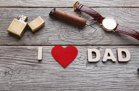 Happy Fathers Day card with male presents, love dad letters, watch and other man things on rustic wood backgroundの写真素材