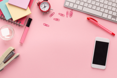 Fashion beauty blogger working space with laptop keyboard, makeup products, stationery and smartphone with blank screen on pink background. Girlish workplace with copy space for text, top viewの写真素材