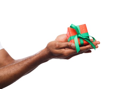 Black man holding a gift box in hands isolated on white background. Present, holiday, congratulations conceptの写真素材