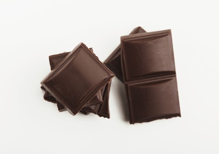 Dark chocolate bar pieces isolated on white background, cutoutの写真素材