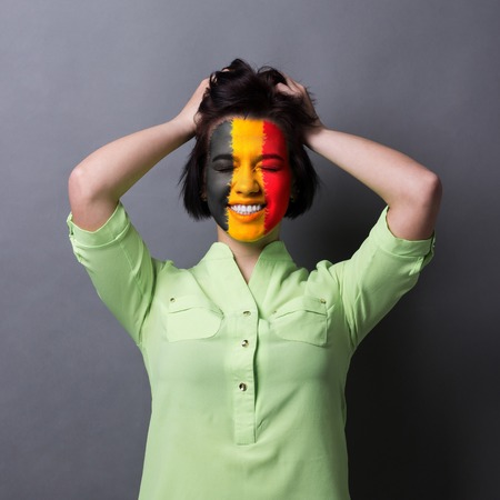 Portrait of happy woman with the flag of England painted on her face. Football or soccer team fan,...