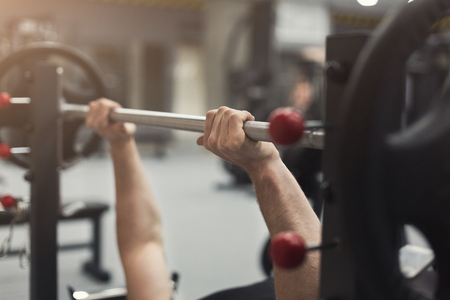Unrecognizable bodybuilder doing heavy deadlifts in modern fitness center. Strong man exercising with dumbbell at gym, copy spaceの写真素材