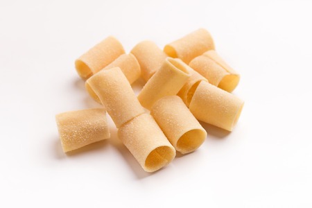Pile of raw paccheri isolated on white background. Traditional Italian pastaの写真素材