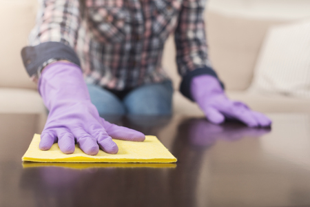 Woman using spray cleaner on wooden surface. Unrecognizable girl polishing furniture, housework and...