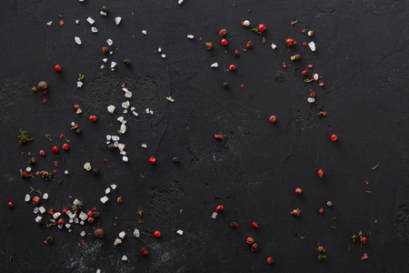 Spices, salt and pepper on black background, copy space.