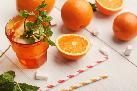 Closeup of citruses assortment and glass of orange juice on white wooden background. Detox, breakfast and healthy lifestyle conceptの写真素材