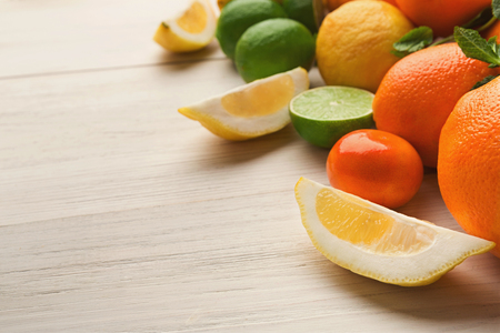Closeup of citruses assortment and glass of orange juice on white wooden background. Detox, breakfast and healthy lifestyle conceptの写真素材