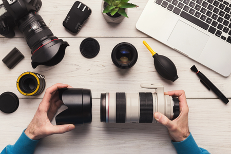 Photo camera lens repair. Technician engineer disassembling, align and adjust camera lens. Engineers hands and maintenance support of broken photographic optic and optical part, top viewの写真素材