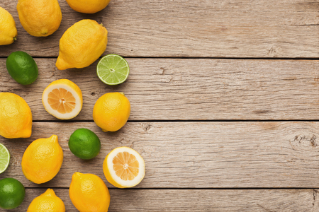 Border of assorted citruse fruits on rustic wooden background, copy space. Top view on lemons and limes , flat layの写真素材