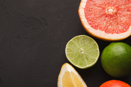 Closeup of various citruses on black slate background. Detox, breakfast and healthy lifestyle concept, copy spaceの写真素材