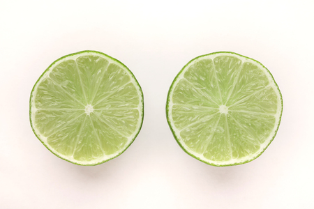 Two halves of lime fruit isolated on white background, cutoutの写真素材