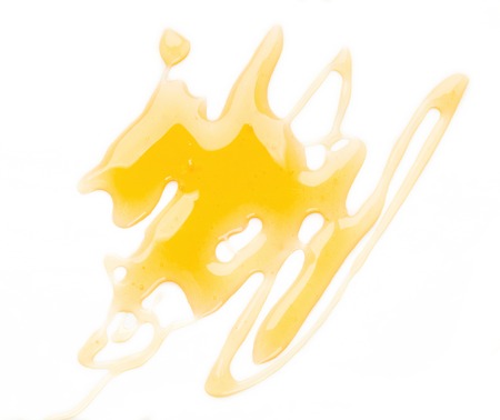 Golden honey stains isolated on white background, cutout, top viewの写真素材