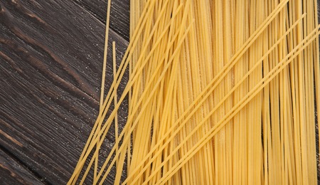 Raw italian spaghetti on wooden background with copy space, top viewの写真素材