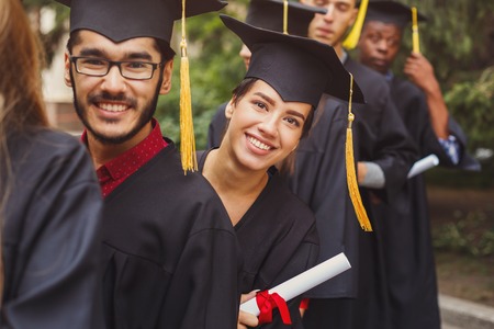 Group of multiethnic students holding their diplomas on graduation day, Happy people celebrating education degree, copy spaceの写真素材