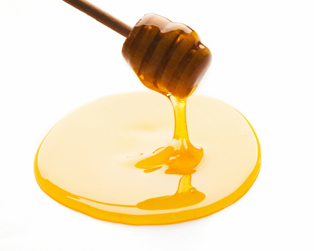 Wooden dipper and honey isolated on white background, cutoutの写真素材